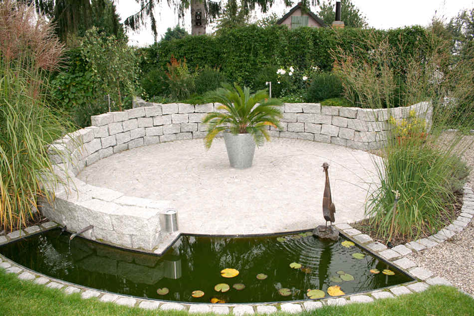 gepflasterte Sitzecke mit Teich und Wasserlauf